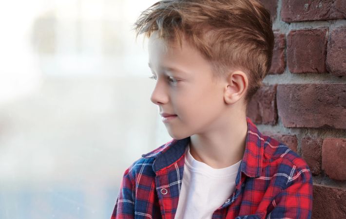A child looking out the window, practicing the 20-20-20 rule. 