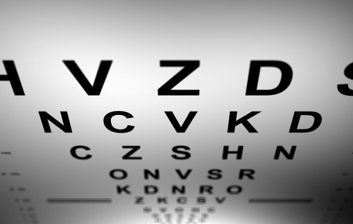 A close-up view of an eye chart, with large bold letters at the top and smaller letters below, gradually decreasing in size, used for testing vision clarity.